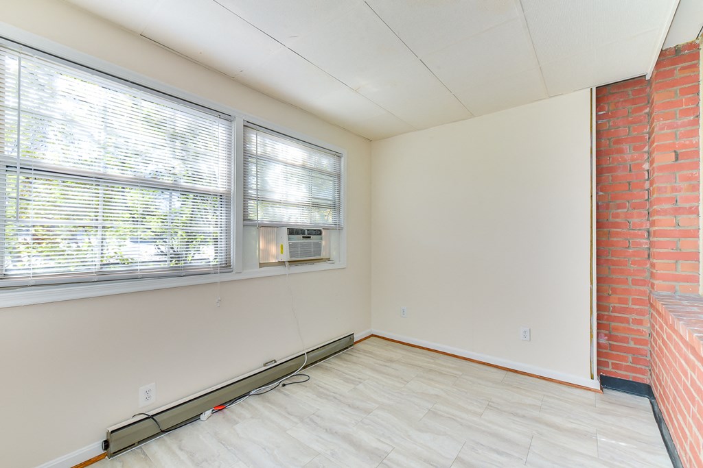 sunroom with exposed brick wall and woodlike flooring at 4020 calvert street apartments in washington dc