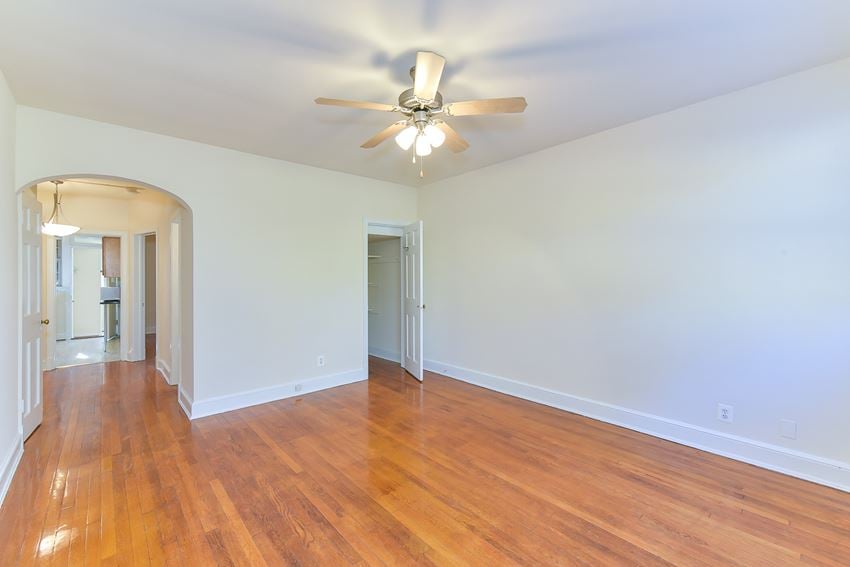vacant living area with hardwood flooring, ceiling fan and view of kitchen at 4020 calvert street apartments in washington dc - Photo Gallery 1