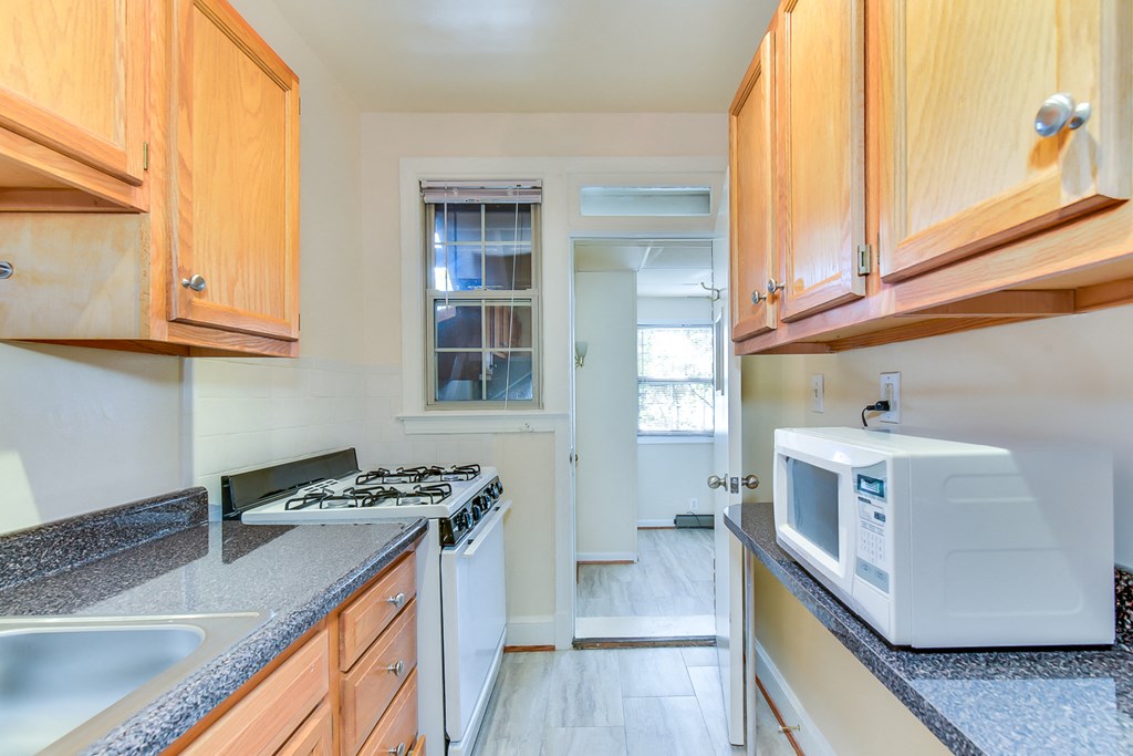 kitchen with gas range, wood cabinetry and energy efficient appliances at 4020 calvert street apartments in washington dc