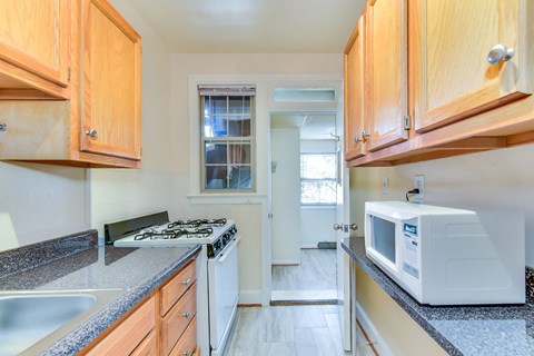 a kitchen with wood cabinets and white appliances and granite counter tops