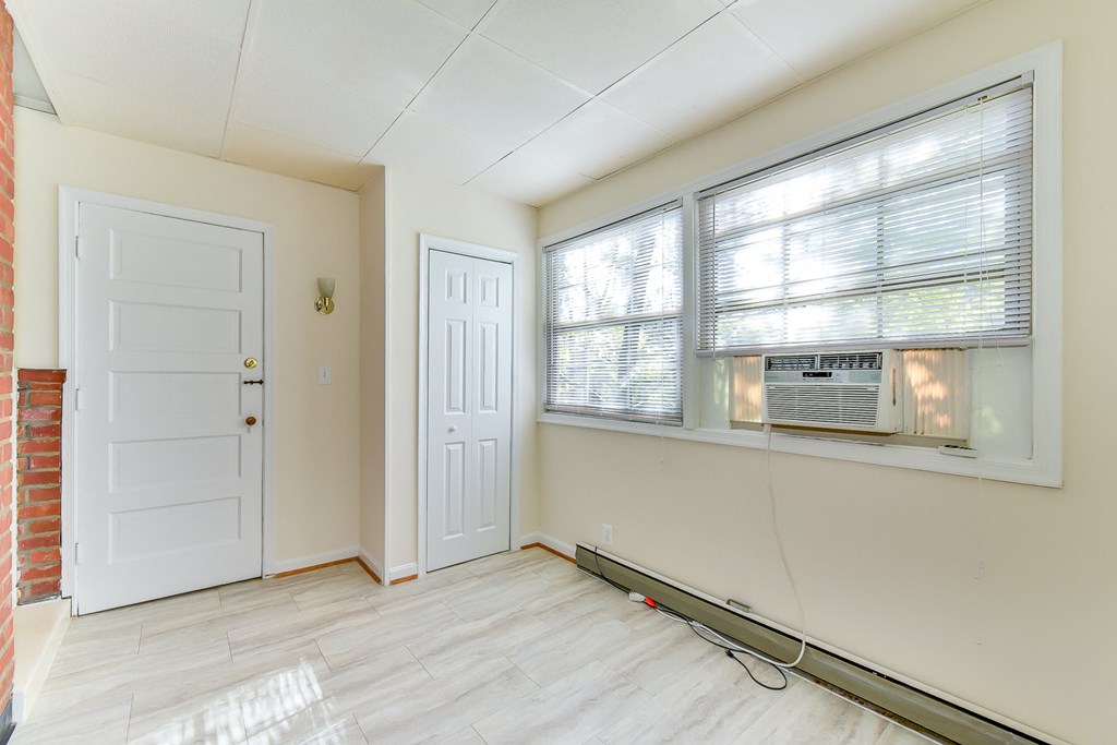sunroom with exposed brick wall and woodlike flooring at 4020 calvert street apartments in washington dc