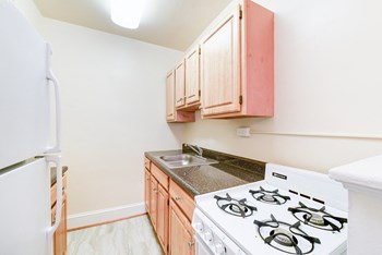 kitchen with gas range, sink and refrigerator at 4031 davis place apartments in washington dc - Photo Gallery 2