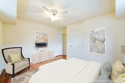 bedroom with bed, dresser, seating area and ceiling fan at 4031 davis place apartments in washington dc