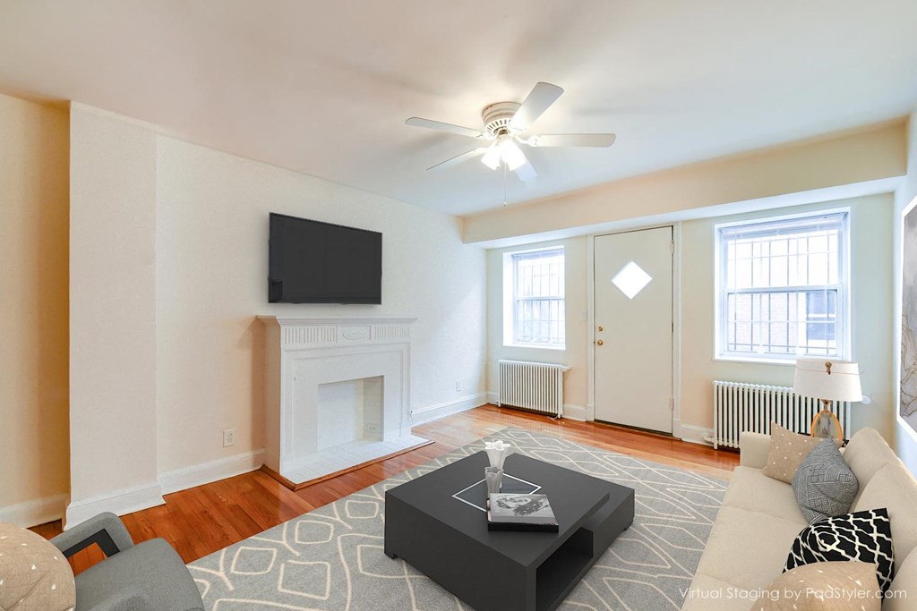 living area with sofa, coffee table, tv, large windows, hardwood floors and ceiling fan at 4031 davis place apartments in washington dc