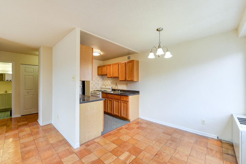 kitchen with wood cabinetry, gas range and view of dining area  at twin oaks apartments columbia heights washington dc