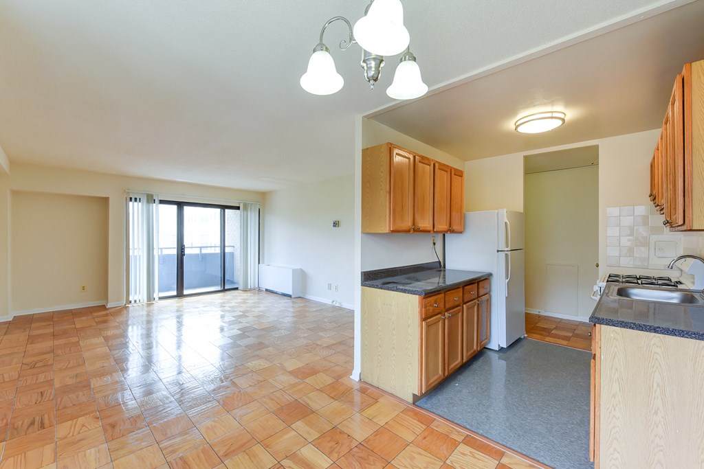 kitchen with wood cabinetry, gas range and view of living area at twin oaks apartments columbia heights washington dc