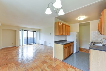 kitchen with wood cabinetry, gas range and view of living area at twin oaks apartments columbia heights washington dc - Photo Gallery 23