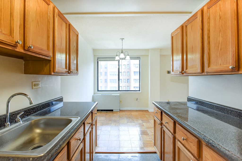 kitchen with wood cabinetry and view of dining area at twin oaks apartments in columbia heights washington dc