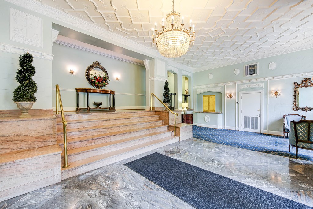 lobby lounge with social seating, ornate ceiling and stairs leading to elevators at the frontenac apartments in van ness washington dc