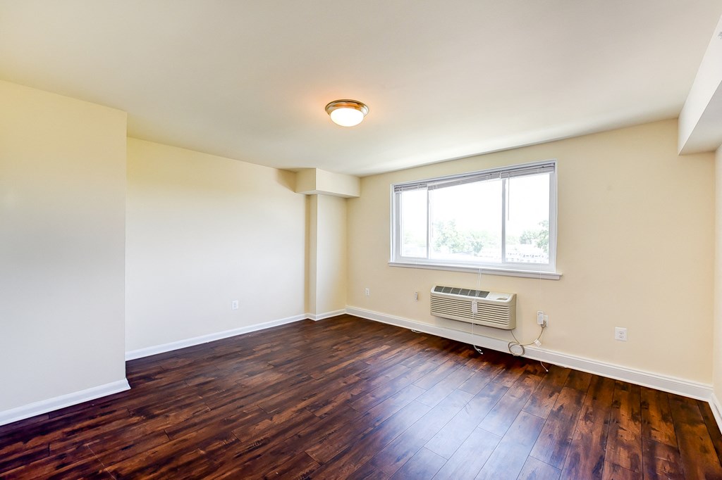 vacant living area with hardwood flooring and large windows at 734 longfellow street apartments in washington dc