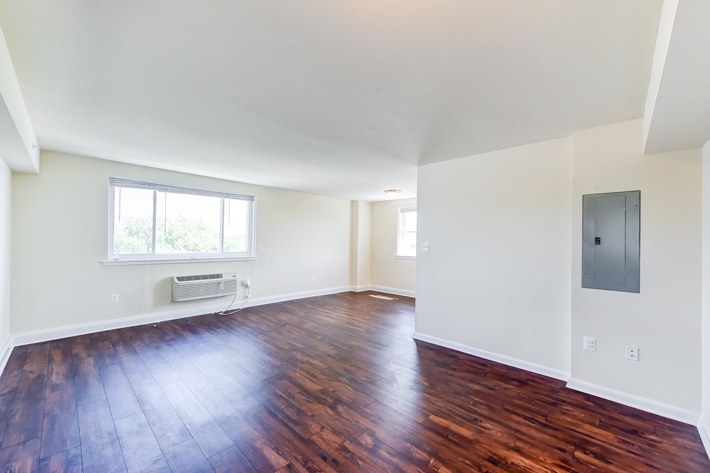 vacant living area with hardwood flooring and large windows at 734 longfellow street apartments in washington dc