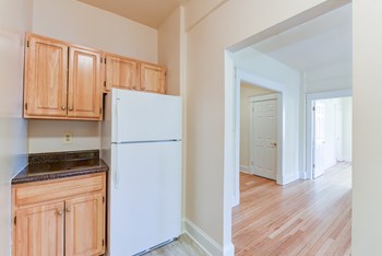 kitchen with wood cabinetry, refrigerator  and view of living area  at twin oaks apartments columbia heights washington dc - Photo Gallery 5