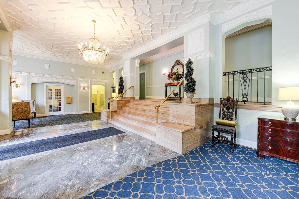 lobby lounge with social seating, ornate ceiling and stairs leading to elevators at the frontenac apartments in van ness washington dc