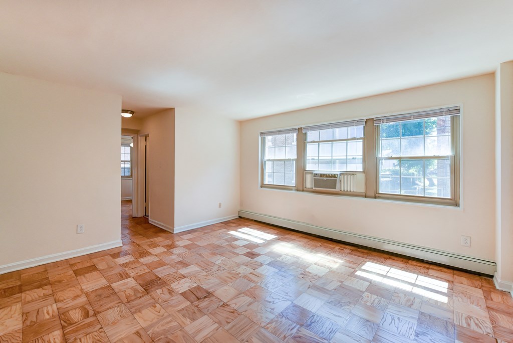 the living room and dining room of an empty house with wood flooring