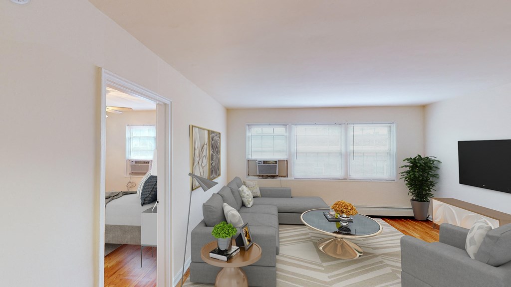 living area with sofa, coffee table, credenza, tv, large windows, view of bedroom hardwood floors at alpha house apartments in washington dc