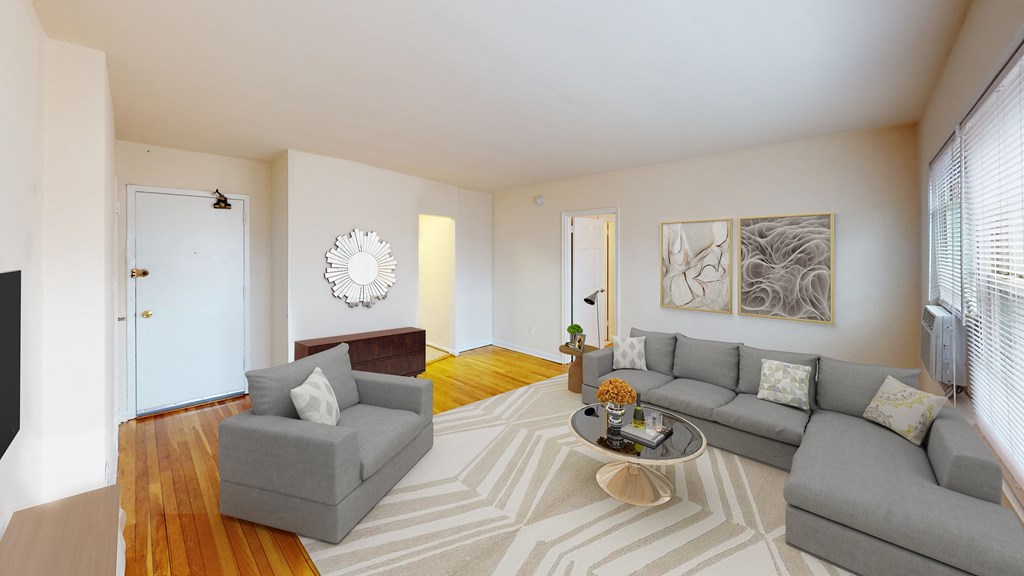 living area with sofa, coffee table, credenza, tv, large windows and hardwood floors at alpha house apartments in washington dc