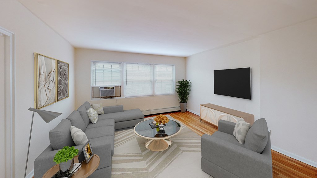 living area with sofa, coffee table, credenza, tv, large windows and hardwood floors at alpha house apartments in washington dc