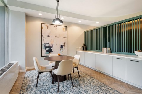 A dining room with a table and chairs.