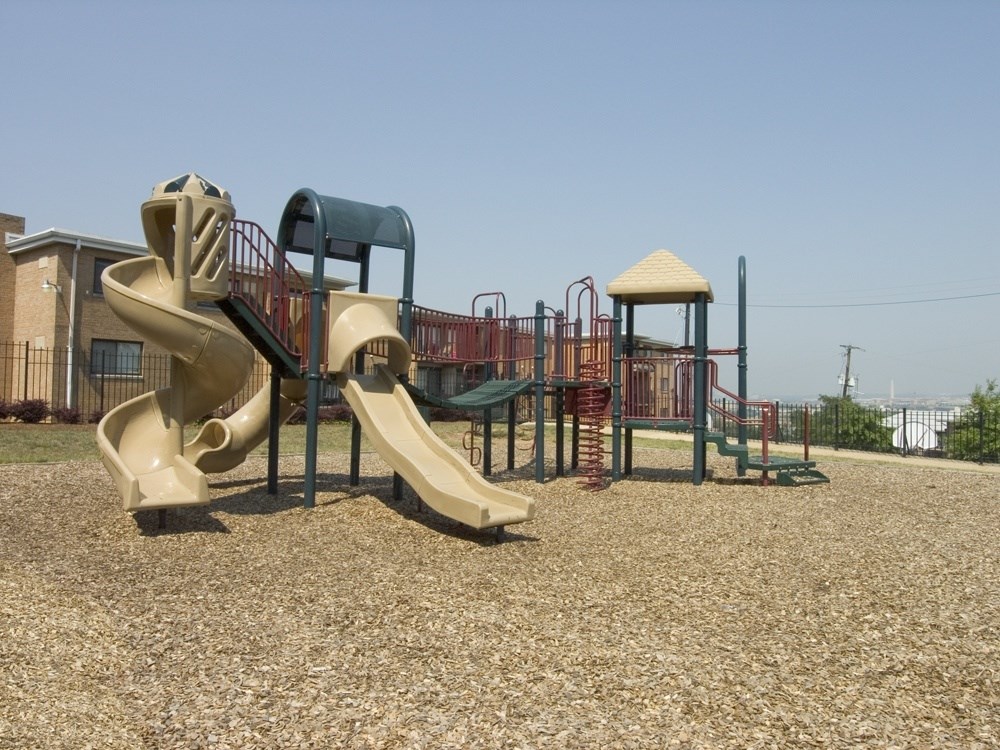 A playground with a slide, swings, and a climbing frame.