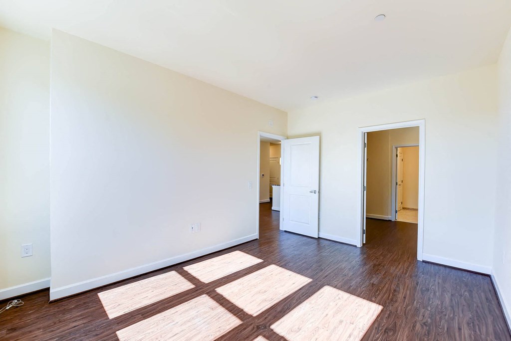 vacant bedroom with hardwood flooring, closet and view of bathroom at archer park apartments in washington dc