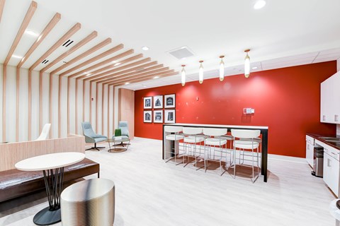 a dining room with a red wall and white tables and chairs
