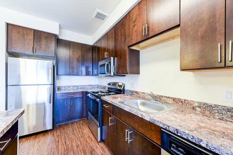 kitchen with island, stainless steel appliances and hardwood flooring at archer park apartments in southeast Washington dc