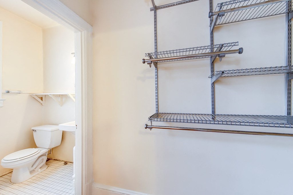 bath room with view of toilet, vanity and custom shelving at 1818 riggs place apartments in washington dc
