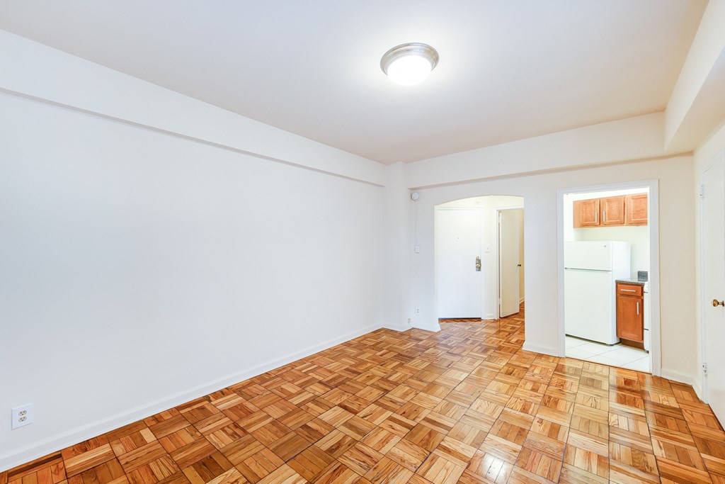 vacant living area with hardwood floors and view of kitchen  at baystate apartments in washington dc