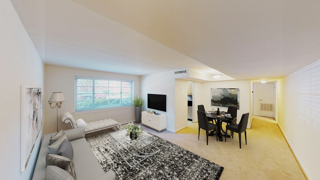 living area with sofa, coffee table, large windows, and views of kitchen and dining areas at cambridge square apartments in bethesda md