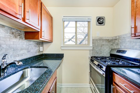 a kitchen with a stove and sink and a window