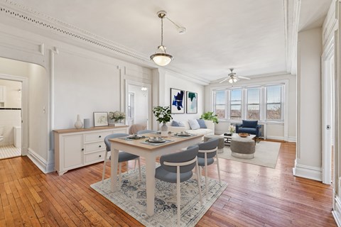 A dining room with a table set for four.