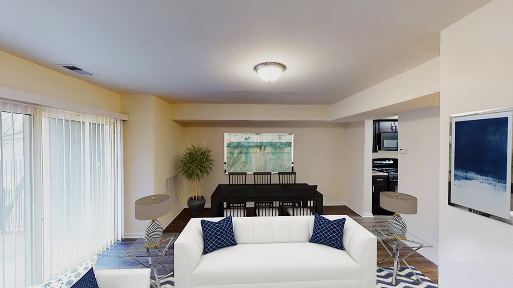 living area with sofa, coffee table, large patio doors and view of dining area at city towns apartments in washington dc