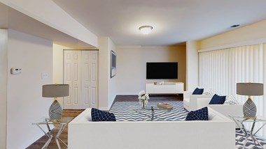 living area with sofa, coffee table, large glass doors, credenza and tv at citytowns apartments in washington dc
