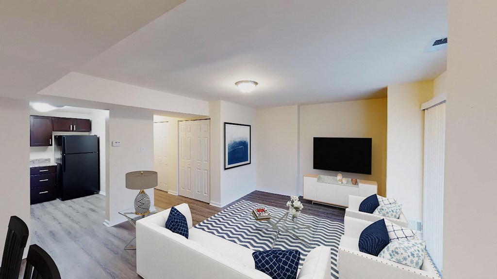 living area with sofa, coffee table, large patio doors, tv, credenza and view of kitchen at city towns apartments in washington dc