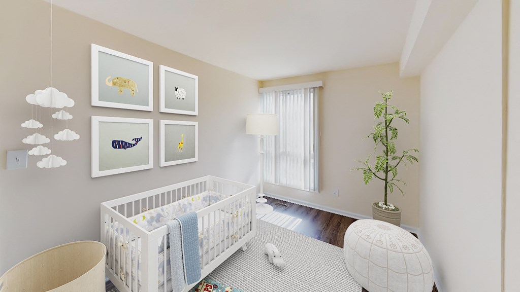 nursery with crib, seating area, large window and hardwood flooring at city towns apartments in washington dc