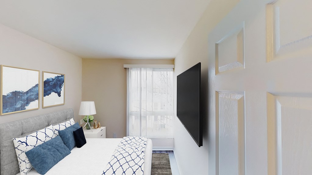 bedroom with bed, night stands, large windows and tv at city towns apartments in washington dc