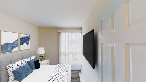 a bedroom with a large bed and a tv on the wall