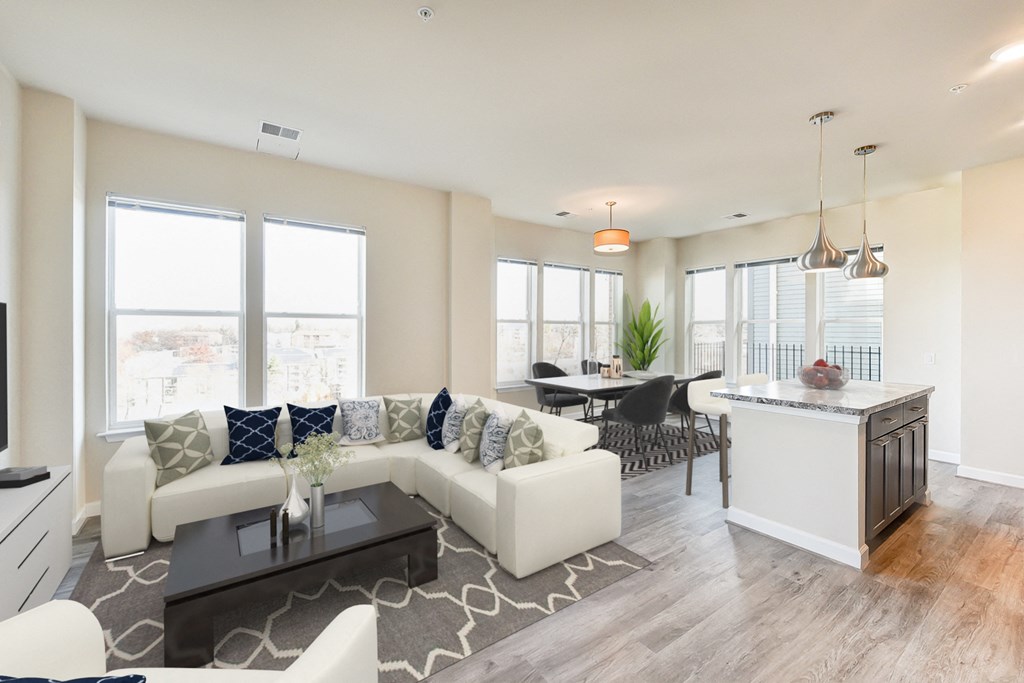 living area with sofa, coffee table , large windows, view of kitchen and view of dining area at city view apartments in washington dc