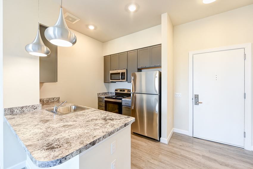 kitchen with hardwood floors, stainless steel appliances and large breakfast bar at city view apartments in washington dc - Photo Gallery 1