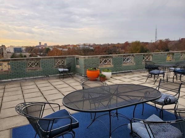 A patio with a table and chairs overlooking a city skyline.