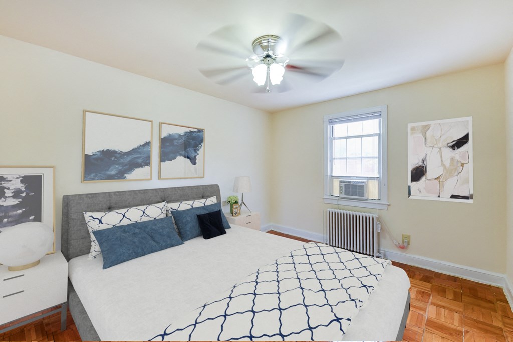 bedroom with bed, nightstands, ceiling fan, large closet and hardwood flooring at colonnade apartments in washington dc