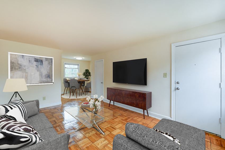 living area with sofa, coffee table, large windows, and view of dining areas at colonnade apartments in washington dc