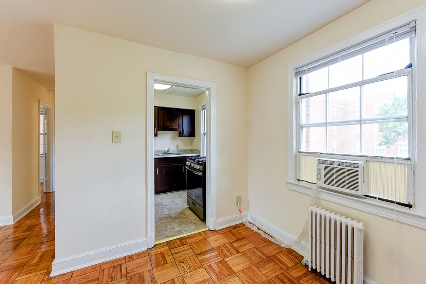 Dining area with view of kitchen with window and energy efficient appliances at colonnade apartments in washington dc
