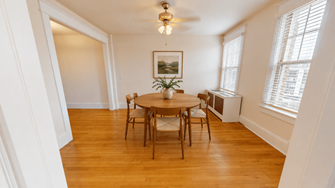 A dining room with a wooden table and chairs.