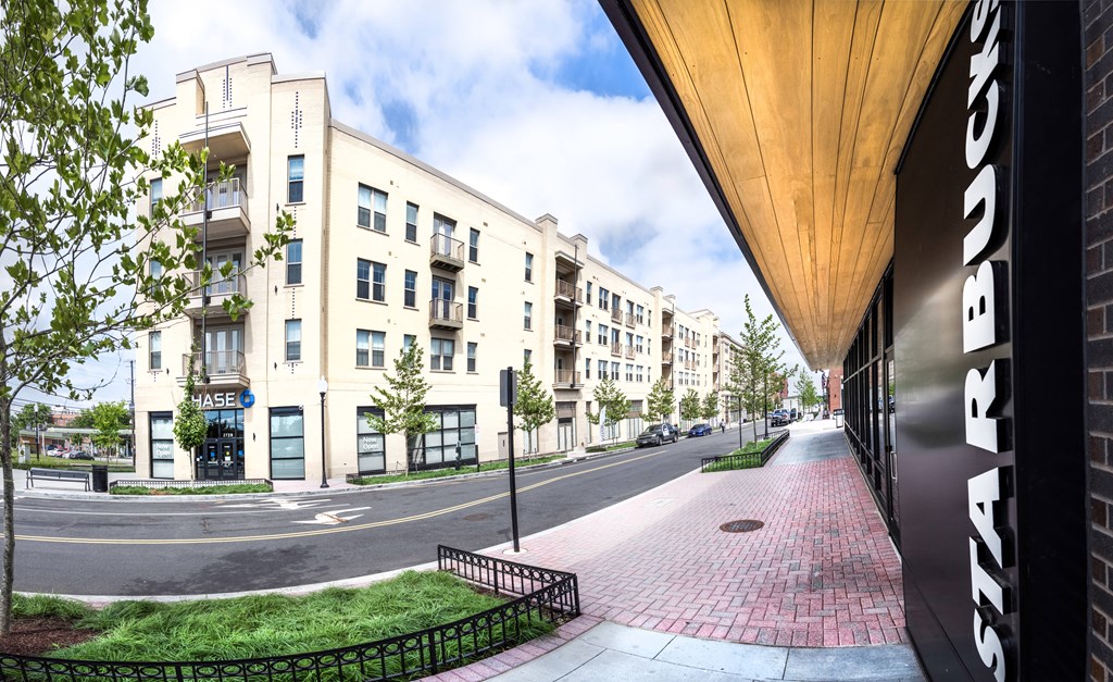 a view of a street with apartment buildings and a sidewalk