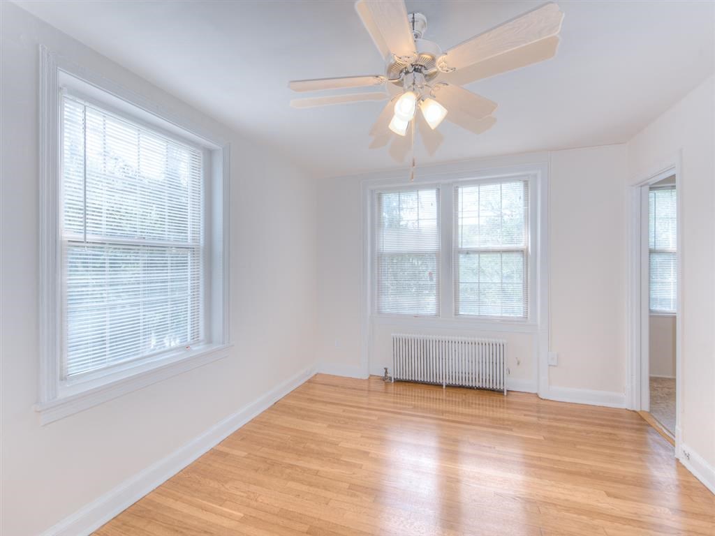 vacant bedroom with hardwood flooring and ceiling fan at 6100 14th Street apartments in washington dc