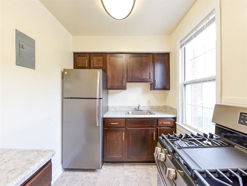 Colonnade-Apartments-Renovated-Kitchens kitchen with espresso cabinetry, stainless steel appliances, gas range and window at the colonnade apartments in washington dc
