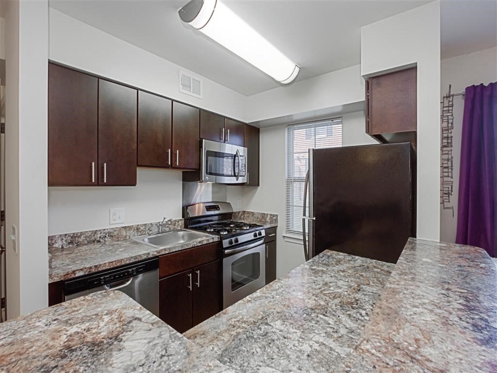 kitchen with espresso cabinetry, breakfast bar and window at fairway park apartments in washington dc