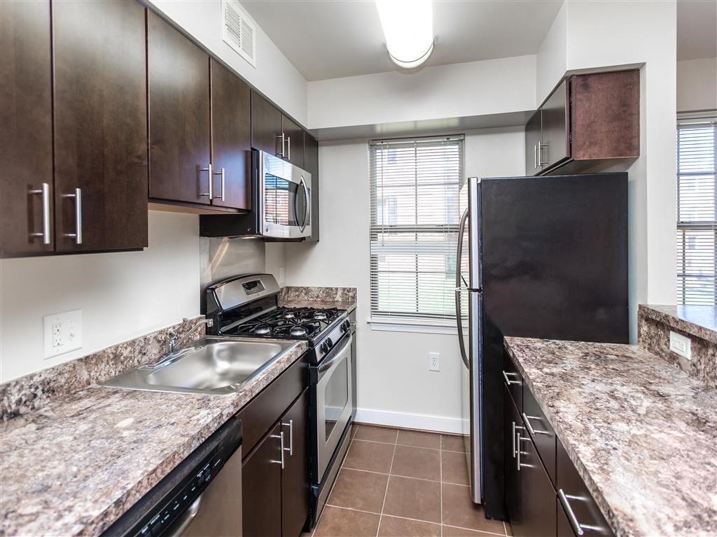 kitchen with espresso cabinetry, breakfast bar and window at fairway park apartments in washington dc