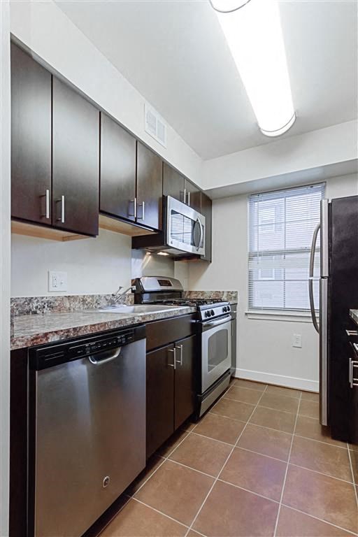 kitchen with espresso cabinetry, breakfast bar and window at fairway park apartments in washington dc